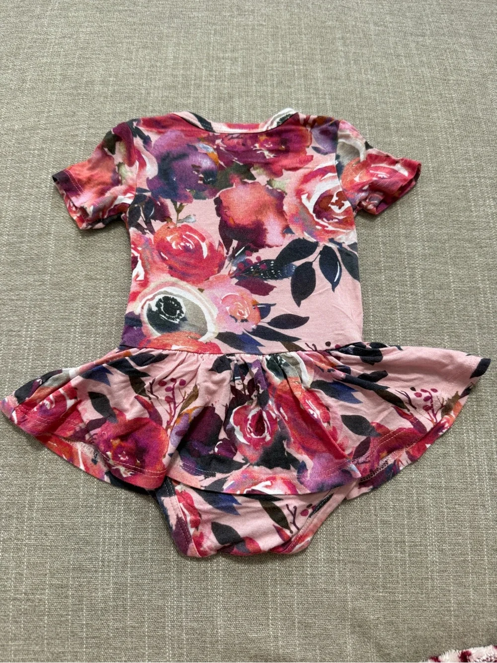 Posh Peanut twirl bodysuit features a Dusk Rose floral print 0-3M